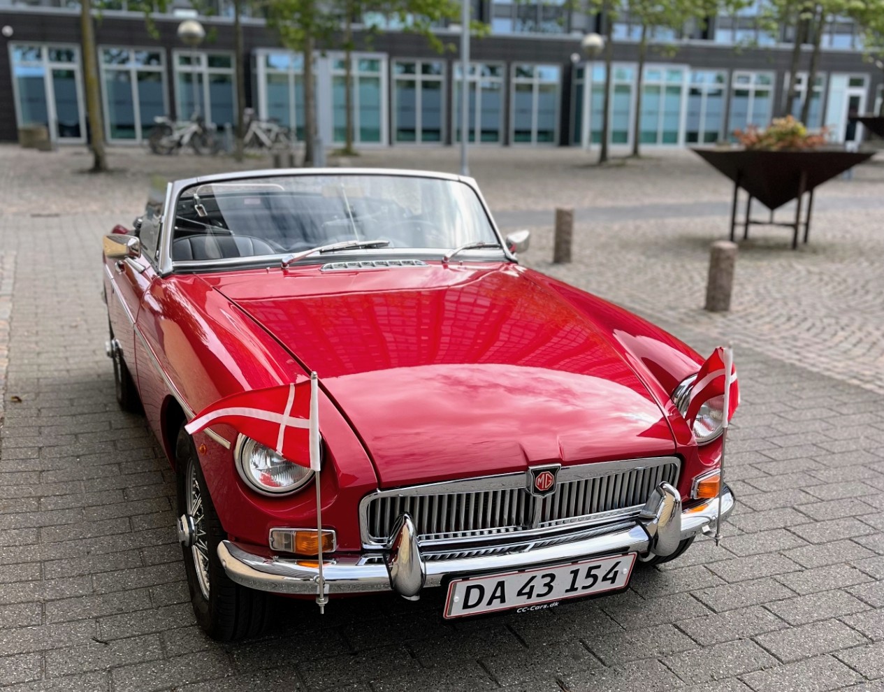 Rød klassisk MG cabriolet med flag.